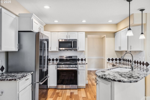 5364 Rosewood St, Lake Oswego, OR 97035 - kitchen with appliances with stainless steel finishes, a sink, a peninsula, tasteful backsplash, and light wood finished floors