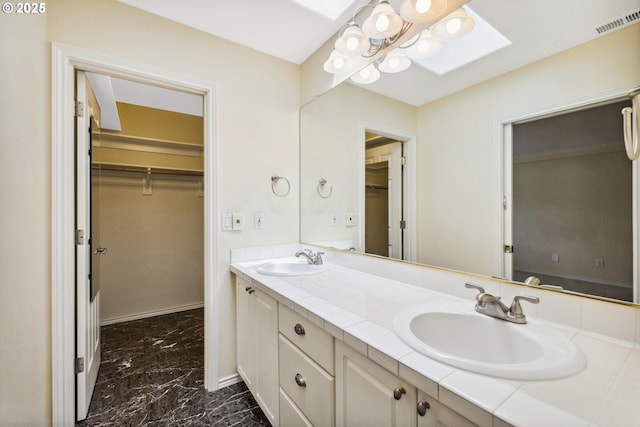 5364 Rosewood St, Lake Oswego, OR 97035 - full bath with a skylight, marble finish floors, double vanity, a walk in closet, and baseboards