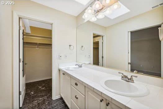 5364 Rosewood St, Lake Oswego, OR 97035 - bathroom featuring marble look tiles, double vanity, a walk in closet, and a skylight