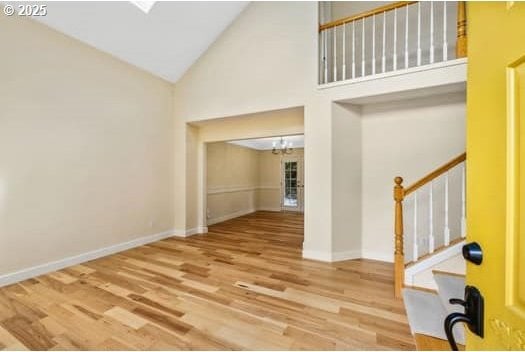 5364 Rosewood St, Lake Oswego, OR 97035 - foyer with high vaulted ceiling, a chandelier, wood finished floors, stairs, and baseboards