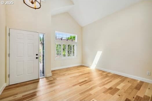 5364 Rosewood St, Lake Oswego, OR 97035 - foyer featuring high vaulted ceiling, baseboards, wood finished floors, and a chandelier