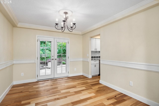 5364 Rosewood St, Lake Oswego, OR 97035 - empty room with a chandelier, ornamental molding, french doors, light wood-style flooring, and baseboards