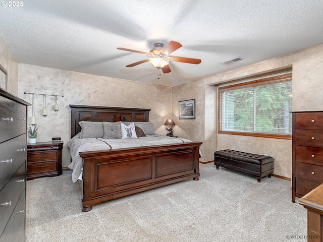 bedroom with visible vents, light colored carpet, a ceiling fan, and a textured ceiling