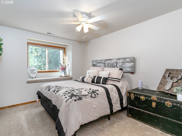 carpeted bedroom with a ceiling fan, visible vents, and baseboards