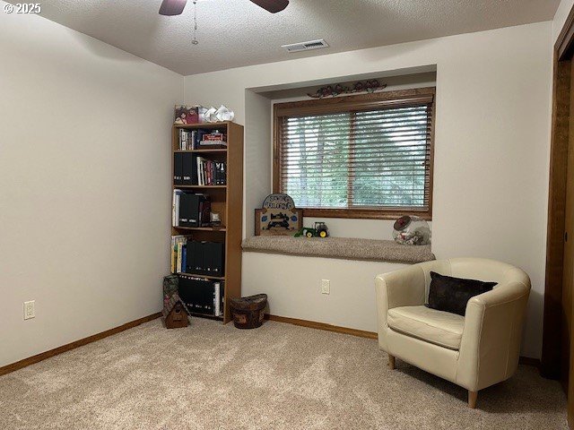 sitting room featuring visible vents, a ceiling fan, a textured ceiling, carpet floors, and baseboards