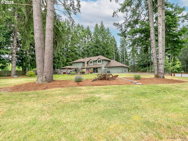 view of front of home featuring a gazebo, a garage, fence, and a front lawn