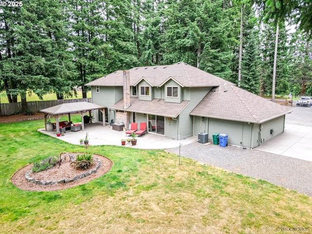 view of front of property featuring a patio, cooling unit, fence, a shingled roof, and a front lawn