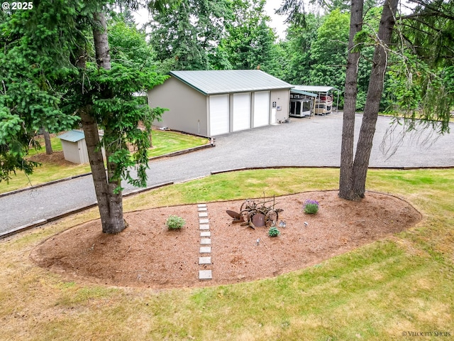 view of yard with a detached garage and an outbuilding