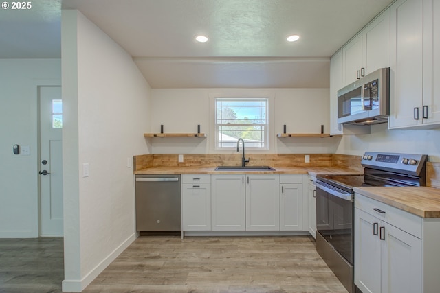 355 W Berdine St, Roseburg, OR 97471 - kitchen featuring stainless steel appliances, open shelves, a sink, light wood finished floors, and recessed lighting