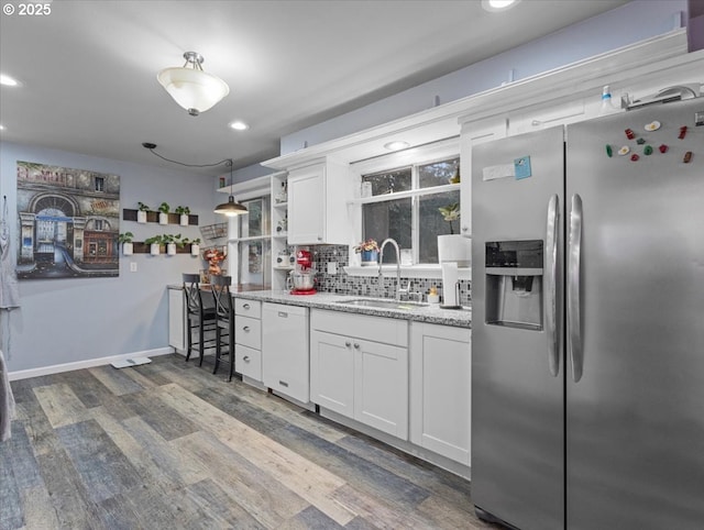 kitchen featuring tasteful backsplash, white cabinetry, sink, white dishwasher, and stainless steel fridge with ice dispenser