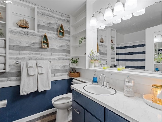 bathroom with vanity, a shower with curtain, toilet, and wood walls