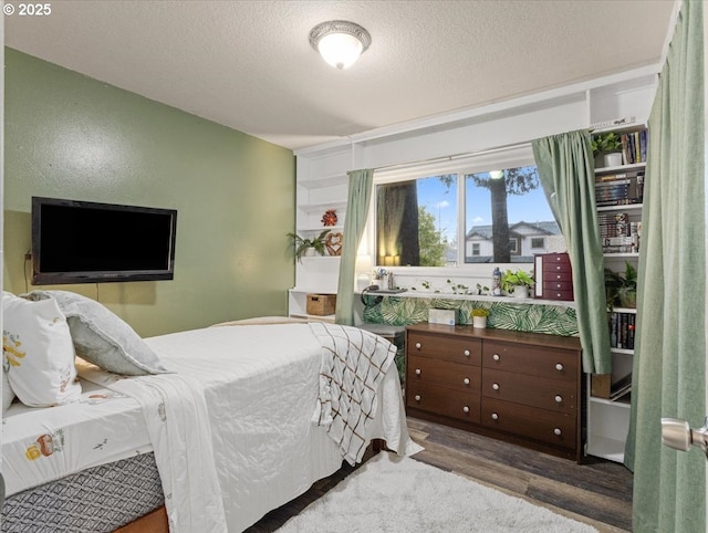 bedroom with hardwood / wood-style floors and a textured ceiling