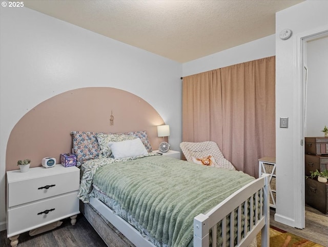 bedroom with dark hardwood / wood-style flooring and a textured ceiling