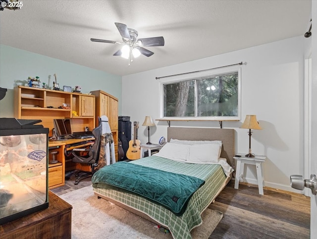 bedroom with ceiling fan, dark wood-type flooring, and a textured ceiling