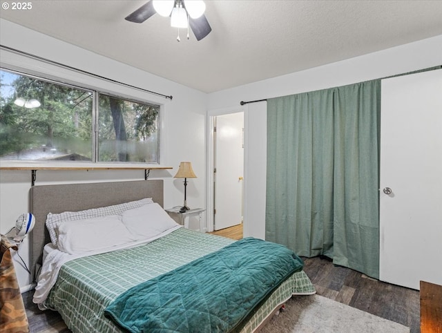 bedroom featuring hardwood / wood-style flooring, a textured ceiling, and ceiling fan