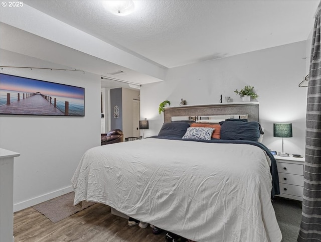 bedroom with hardwood / wood-style flooring and a textured ceiling