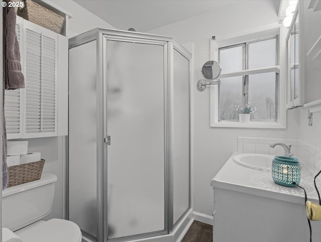 bathroom with walk in shower, vanity, toilet, and hardwood / wood-style flooring