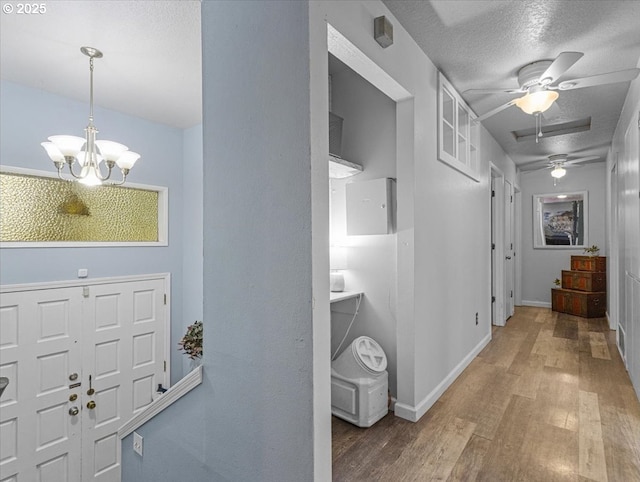 entrance foyer featuring wood-type flooring, ceiling fan with notable chandelier, and a textured ceiling