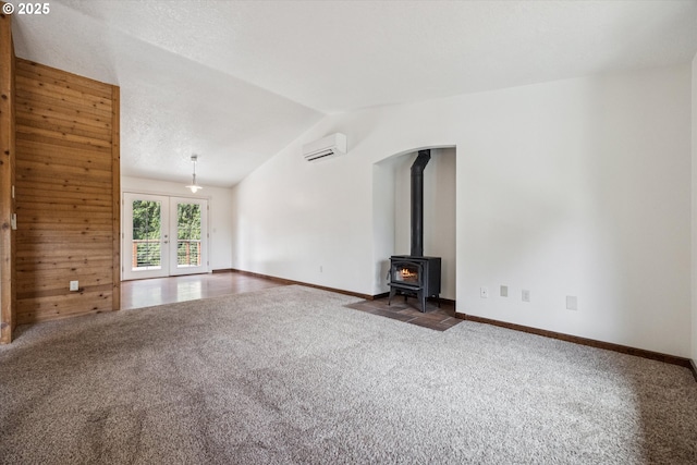 1625 SE Regner Rd, Gresham, OR 97080 - unfurnished living room featuring carpet flooring, a wall mounted air conditioner, lofted ceiling, a wood stove, and french doors