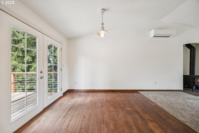 1625 SE Regner Rd, Gresham, OR 97080 - unfurnished dining area featuring a wall unit AC, vaulted ceiling, wood finished floors, and a wood stove