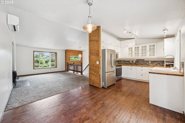 1625 SE Regner Rd, Gresham, OR 97080 - kitchen featuring stainless steel appliances, a wall mounted air conditioner, dark wood-type flooring, and a wood stove