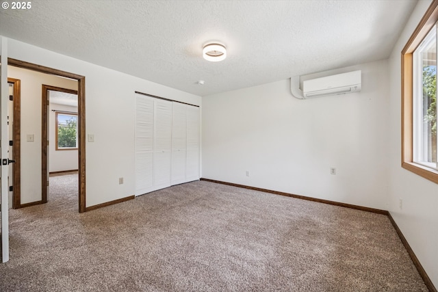 1625 SE Regner Rd, Gresham, OR 97080 - unfurnished bedroom featuring a wall mounted air conditioner, carpet, multiple windows, a textured ceiling, and a closet