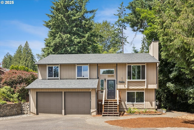 1625 SE Regner Rd, Gresham, OR 97080 - split foyer home featuring a chimney, a garage, a shingled roof, and asphalt driveway
