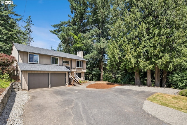 1625 SE Regner Rd, Gresham, OR 97080 - view of front of house with a chimney, driveway, stairway, a garage, and roof with shingles
