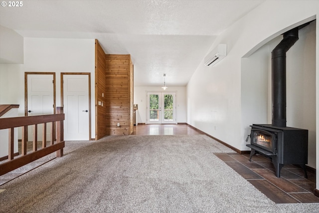 1625 SE Regner Rd, Gresham, OR 97080 - unfurnished living room with a wall mounted air conditioner, a wood stove, french doors, dark colored carpet, and wooden walls