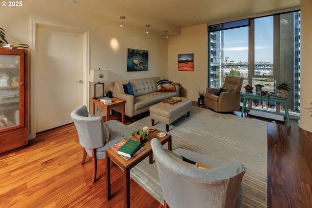 living room featuring wood finished floors, expansive windows, and a view of city