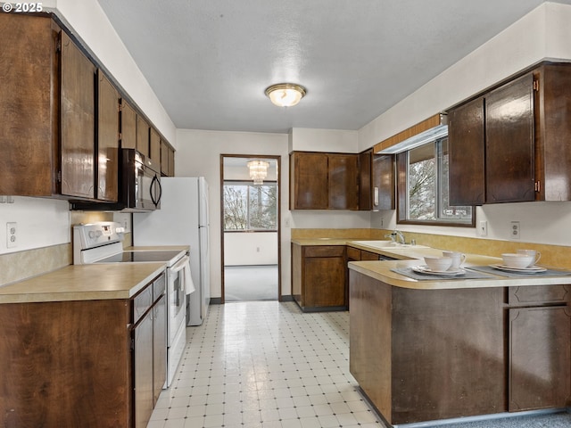 kitchen with sink, dark brown cabinets, kitchen peninsula, and electric stove