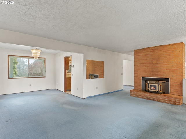 unfurnished living room featuring a wood stove, a textured ceiling, and carpet