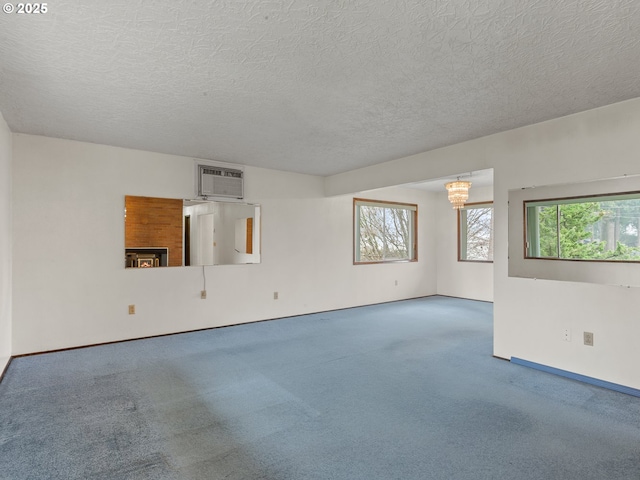 spare room featuring carpet floors, a wall mounted AC, and a textured ceiling