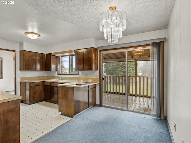 kitchen featuring sink, a healthy amount of sunlight, light colored carpet, and pendant lighting