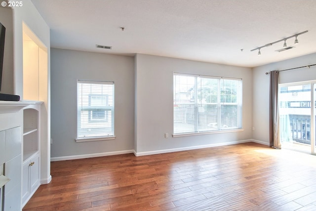 22860 SW Forest Creek Dr Unit 203, Sherwood, OR 97140 - unfurnished living room with track lighting, wood finished floors, and healthy amount of natural light