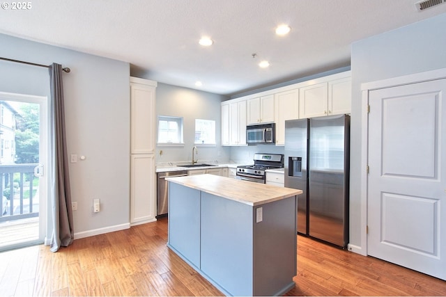 22860 SW Forest Creek Dr Unit 203, Sherwood, OR 97140 - kitchen with appliances with stainless steel finishes, white cabinetry, light countertops, light wood finished floors, and recessed lighting