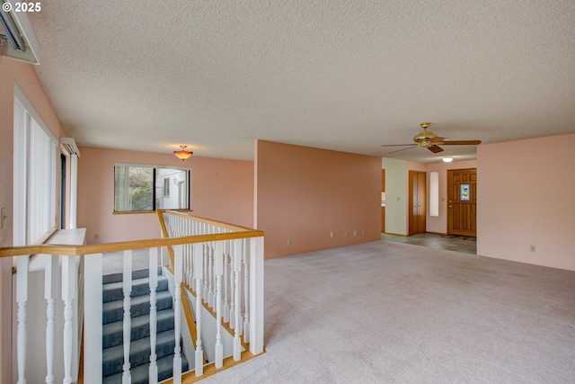 unfurnished room with carpet flooring, a textured ceiling, and ceiling fan