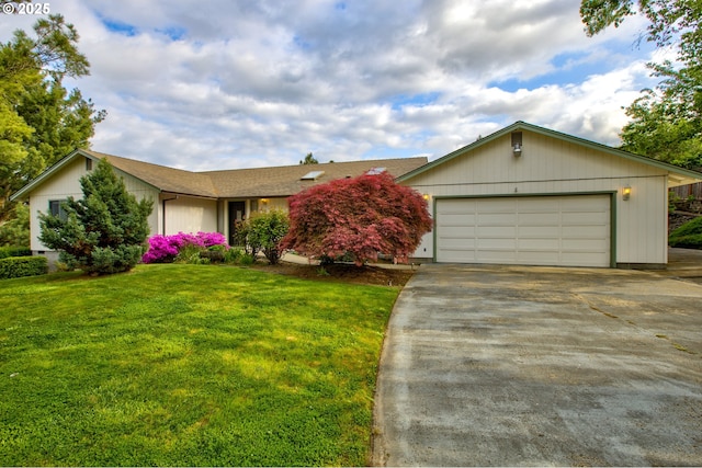 ranch-style home featuring concrete driveway, a garage, a shingled roof, and a front lawn