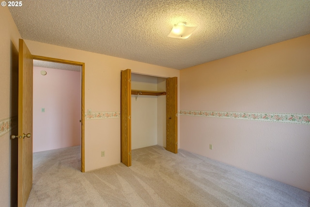 unfurnished bedroom with a textured ceiling, light carpet, and a closet
