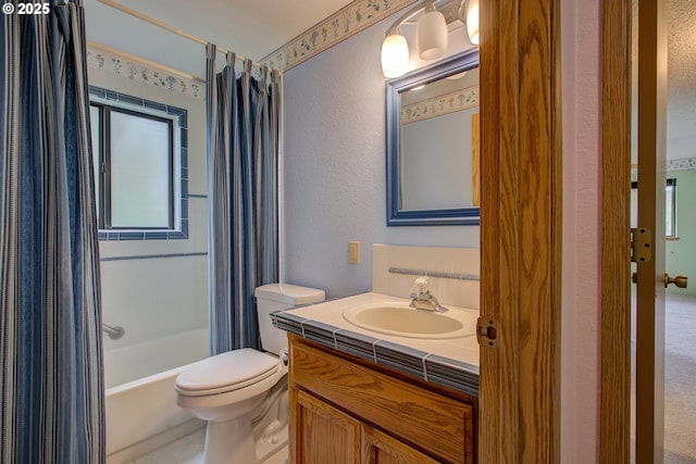 full bath featuring shower / bath combo with shower curtain, a textured wall, toilet, and vanity