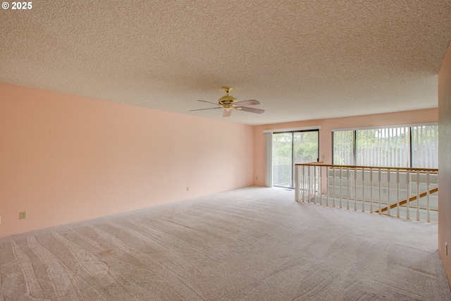 carpeted spare room with a textured ceiling and ceiling fan