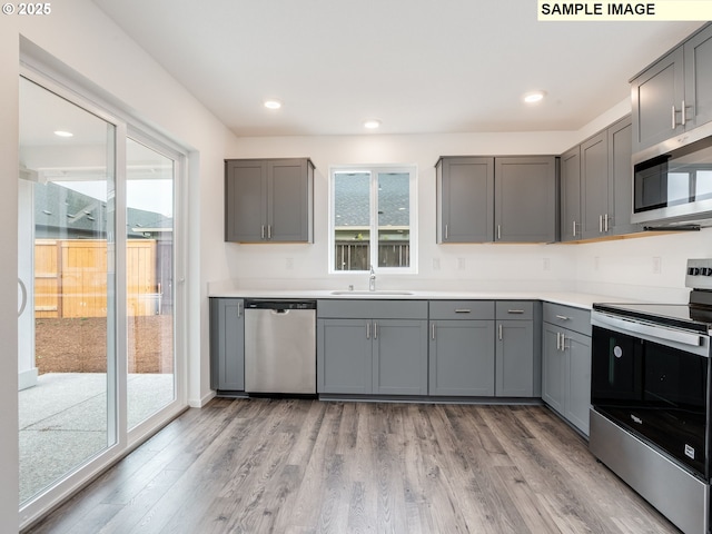 5416 NE 66th Pl, Vancouver, WA 98661 - kitchen with stainless steel appliances, gray cabinetry, light wood finished floors, a sink, and recessed lighting