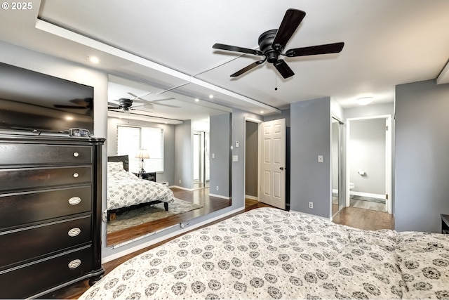 bedroom featuring dark wood-type flooring, connected bathroom, and ceiling fan