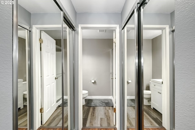 bathroom with vanity, wood-type flooring, and toilet