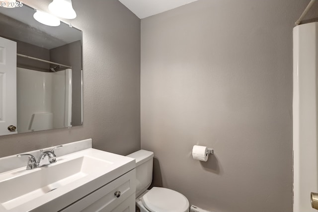 bathroom featuring vanity, a shower, and toilet