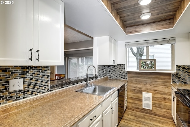 kitchen featuring sink, range, dishwasher, a raised ceiling, and white cabinets