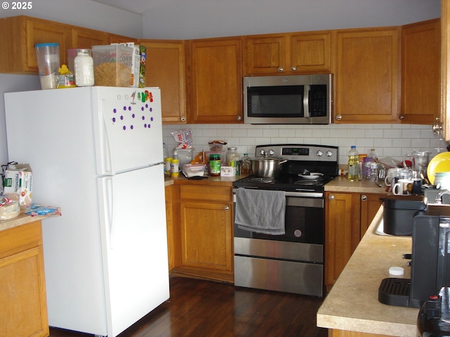 131 NW Makah Ct, Roseburg, OR 97471 - kitchen with appliances with stainless steel finishes, light countertops, tasteful backsplash, and dark wood-style floors
