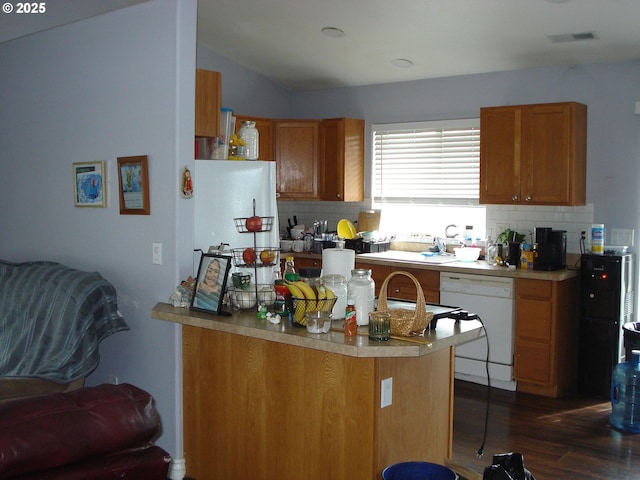 131 NW Makah Ct, Roseburg, OR 97471 - kitchen with dishwasher, backsplash, dark wood-type flooring, brown cabinets, and lofted ceiling
