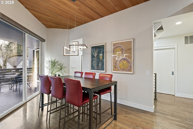 dining room featuring visible vents, wood finished floors, baseboards, and wooden ceiling