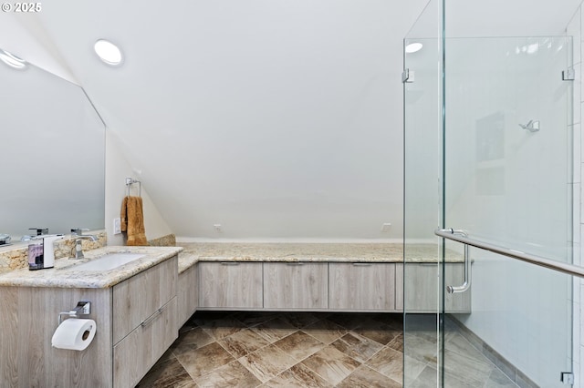 bathroom featuring lofted ceiling, an enclosed shower, and vanity